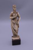 A 19th century European ivory figure on a wooden plinth. 13 cm high overall.