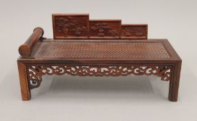 A Chinese hardwood miniature daybed. 23 cm long.