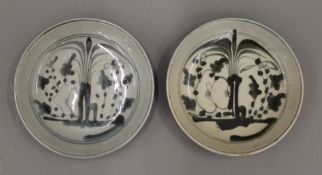 Two small Oriental pottery black and white dishes. 15 cm diameter.