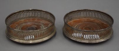 A pair of silver mounted bottle coasters. 12.5 cm diameter.