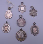 Seven silver hallmarked fobs, including tennis and darts related. 50.5 grammes.