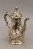 An embossed silver coffee pot with expunged hallmarks. 24 cm high. 28.3 troy ounces total weight.