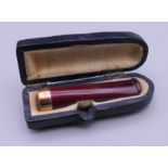 A 9 ct gold mounted cigarette holder, cased. 4.5 cm long.