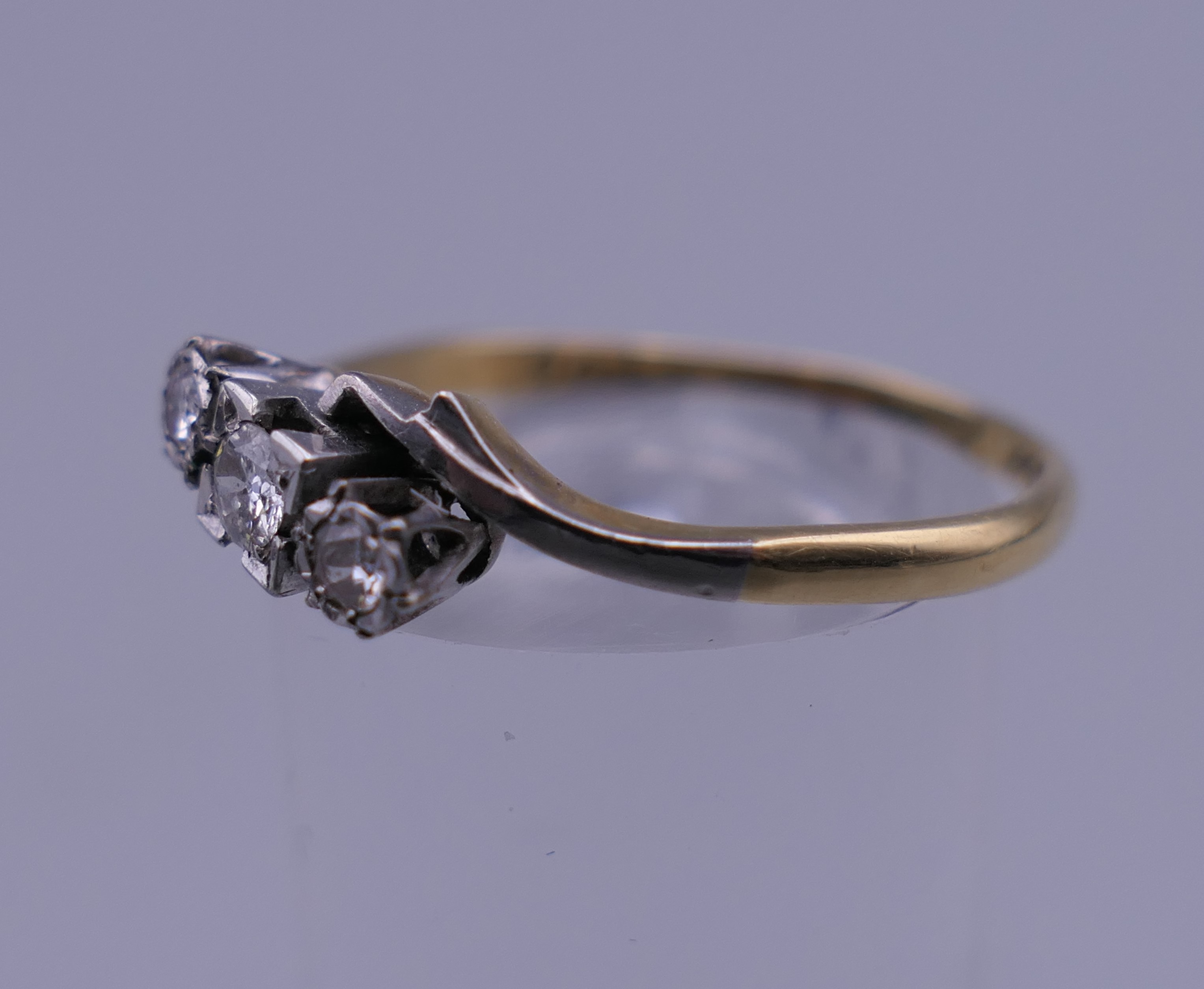 An 18 ct gold and platinum three stone diamond ring. Ring size R/S. 2.6 grammes total weight. - Image 6 of 6