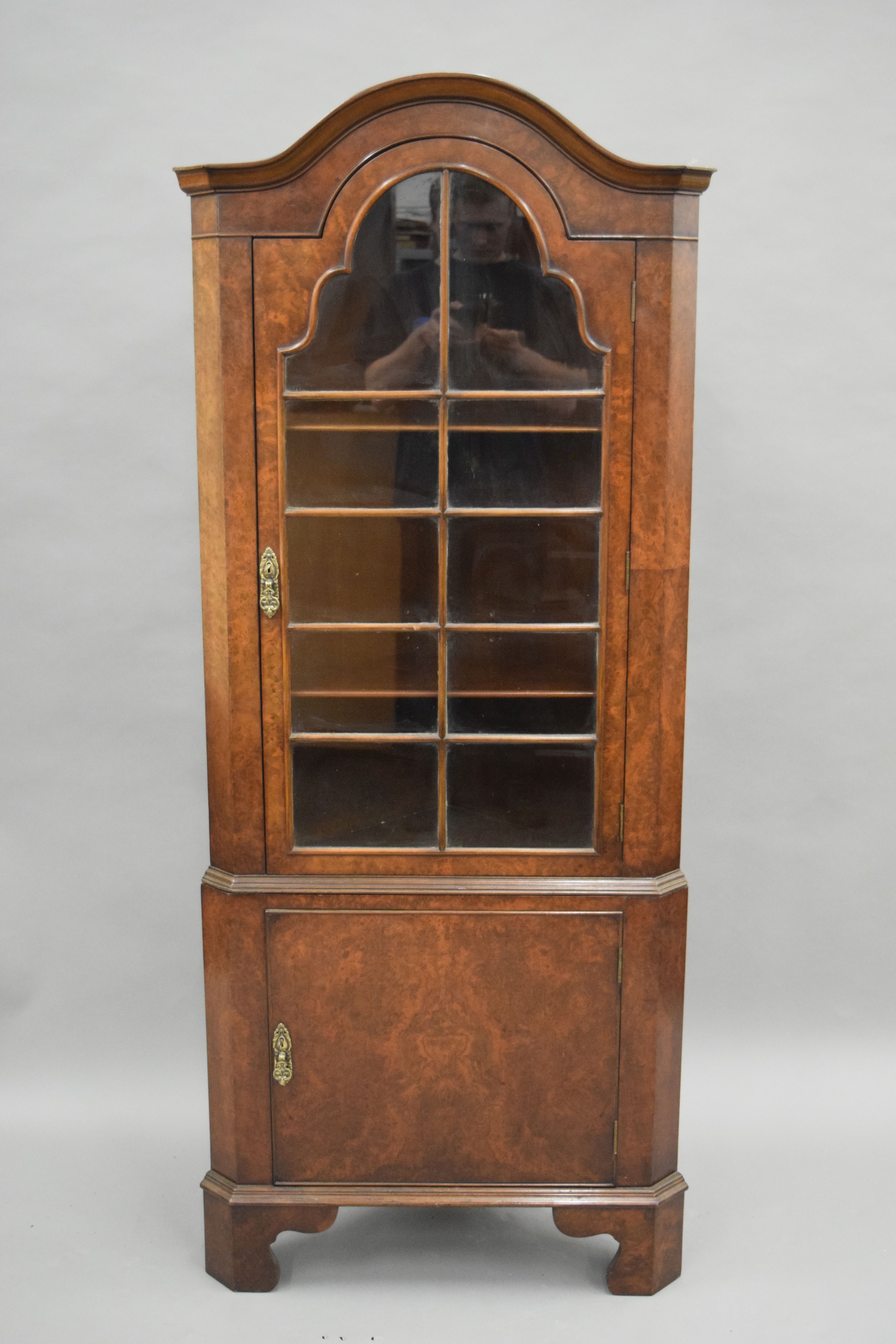 A 20th century walnut corner cabinet. 167 cm high.