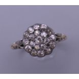 An 18 ct gold and diamond flowerhead ring. Ring size Q. 3.4 grammes total weight.