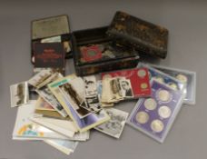 A box containing coins, stamps and cigarette cards.