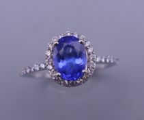 An 18 ct white gold tanzanite and diamond ring. Ring size O. 2.9 grammes total weight.