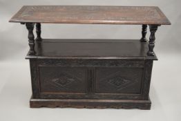 A Victorian carved oak monks bench. 121 cm wide.