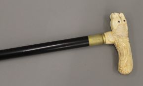 A walking stick with a carved bone handle formed as horse's heads. 90 cm long.