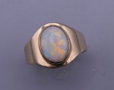 A 9 ct gold oval opal ring. Ring size Q/R. 4.9 grammes total weight.