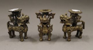 A set of three Chinese bronze dogs of fo candlesticks. Each 9 cm high.