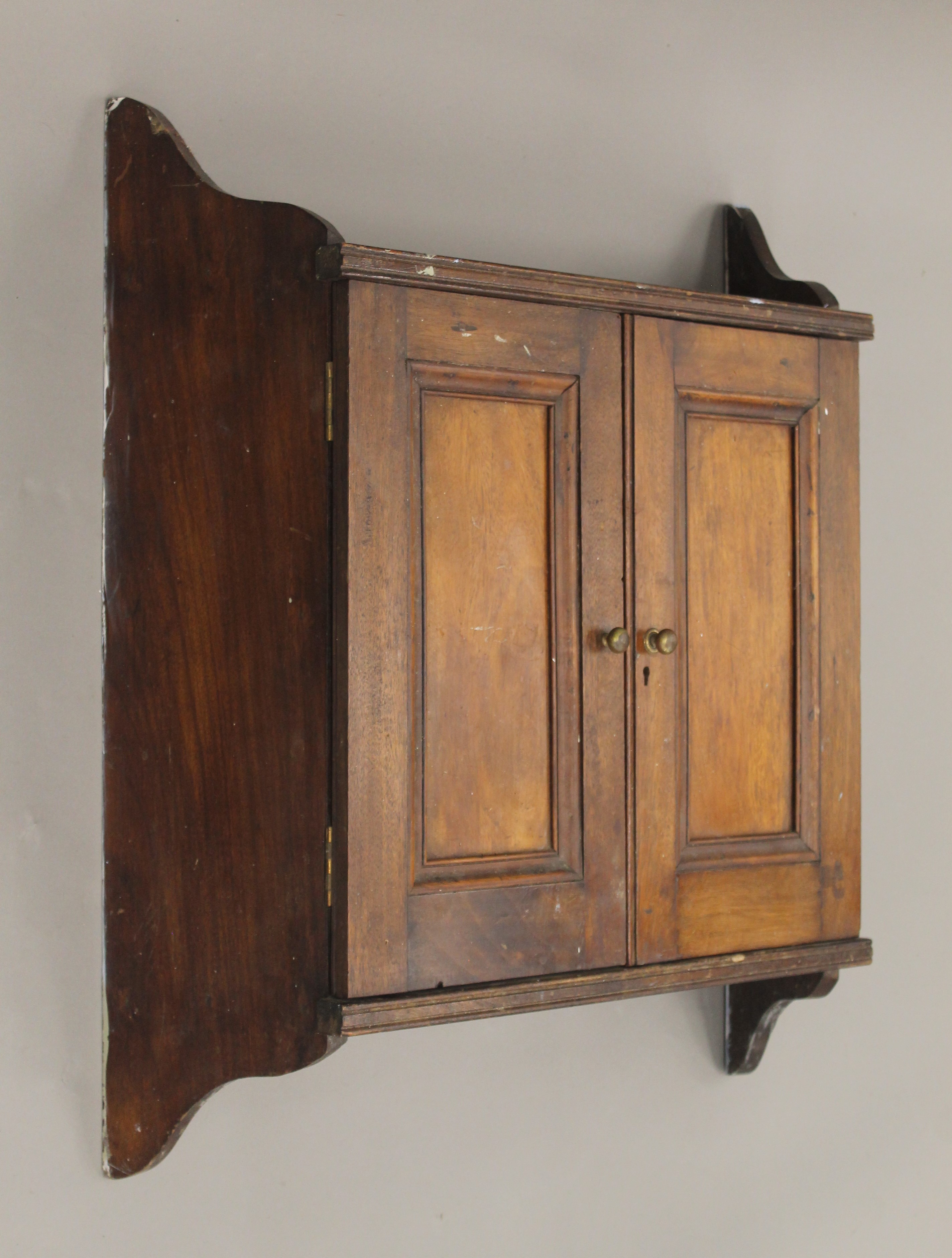 A Victorian walnut two door hanging cupboard. 63 cm wide.