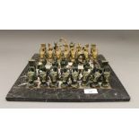 A brass chess set with marble board.