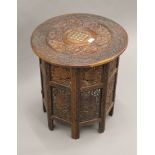 A carved Indian Kashmir folding hardwood table. 53 cm diameter.