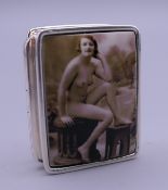 A silver pill box depicting a nude. 3 cm wide.