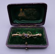 A gold amethyst and seed pearl set bar brooch. 4.5 cm wide. 1.4 grammes total weight.