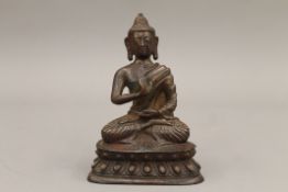 A patinated cast bronze model of Buddha. 15 cm high.