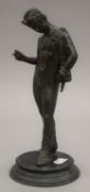 A 19th century classical bronze figure of a nude male on a circular base. 26 cm high.