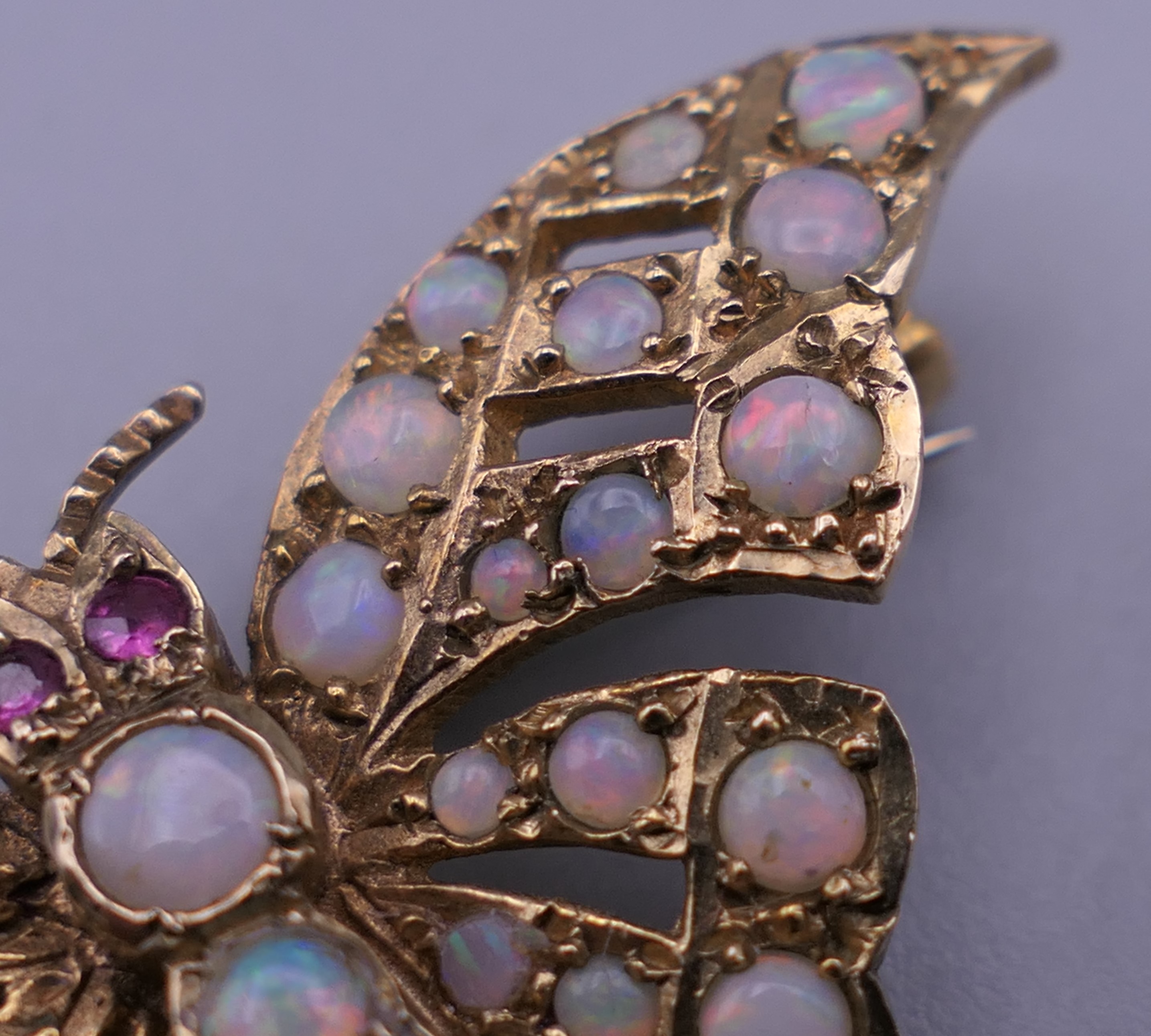 A 9 ct gold opal and ruby set butterfly brooch. 4 cm wide. 6 grammes total weight. - Image 7 of 10
