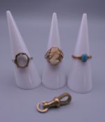 Three 9 ct gold rings and a 9 ct gold clasp. 8.4 grammes total weight.