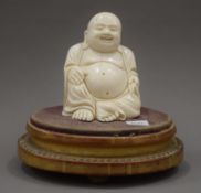 A 19th century carved ivory model of Buddha mounted on a French gilt wood plinth base. 12.