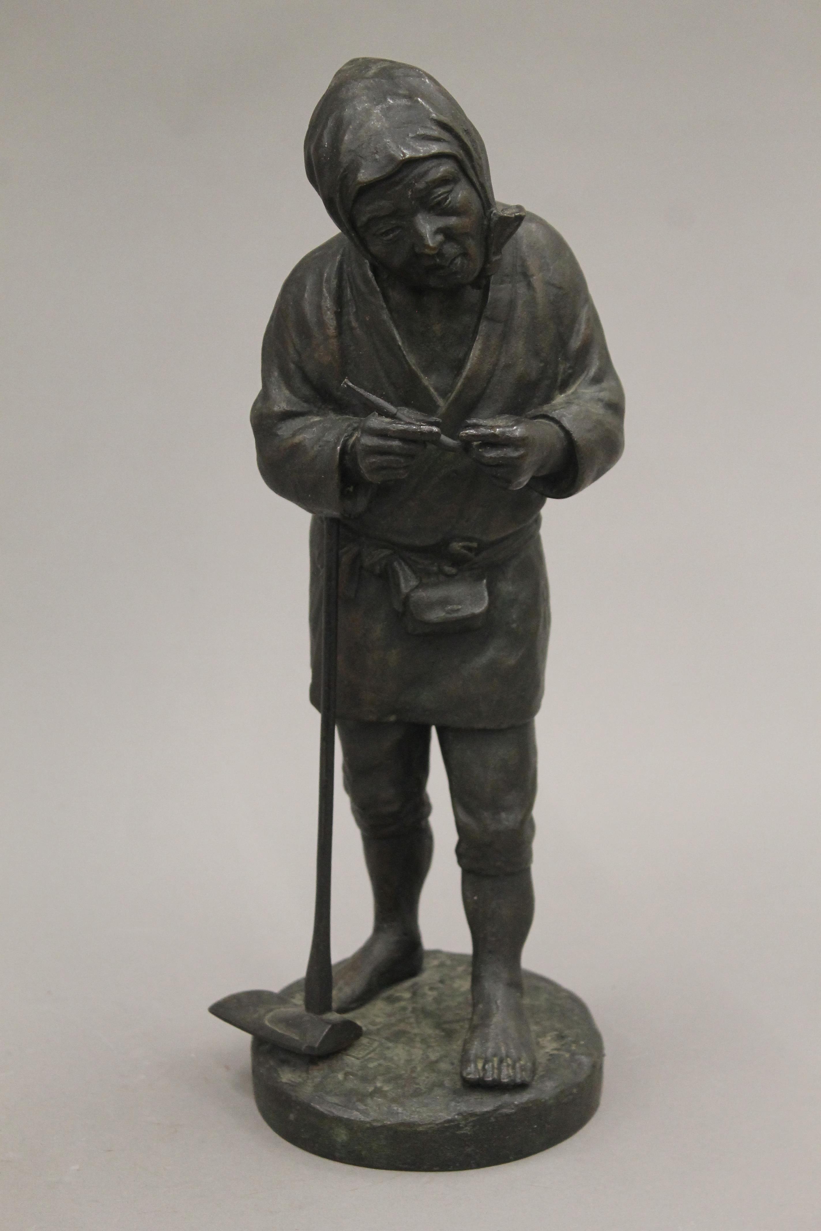 A Japanese Meiji period bronze model of a farmer. 30 cm high.