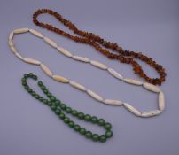 A string of amber beads and two other strings of beads.