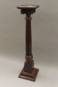 A carved walnut doric top pillar stand. 79 cm high.