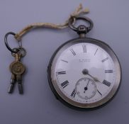 A silver pocket watch, signed D Oehler Ammanford, with two keys. 5 cm diameter.