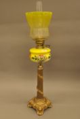 A Victorian gilt spelter oil lamp with yellow reservoir and shade. 82 cm high.