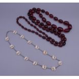 A long string of cherry amber beads and an early 20th century unmarked silver necklace set with