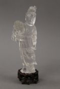 A Chinese carved figure of Guanyin on a wooden stand. 21 cm high.