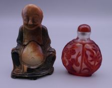 A 19th century soapstone carving of Hotei and a carved red overlay Chinese Peking glass snuff