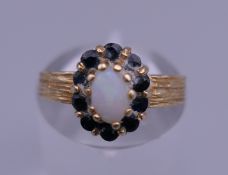 A 9 ct gold opal and sapphire ring. Ring size J/K. 2.1 grammes total weight.