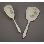 A silver and enamel dressing table brush and a mirror.