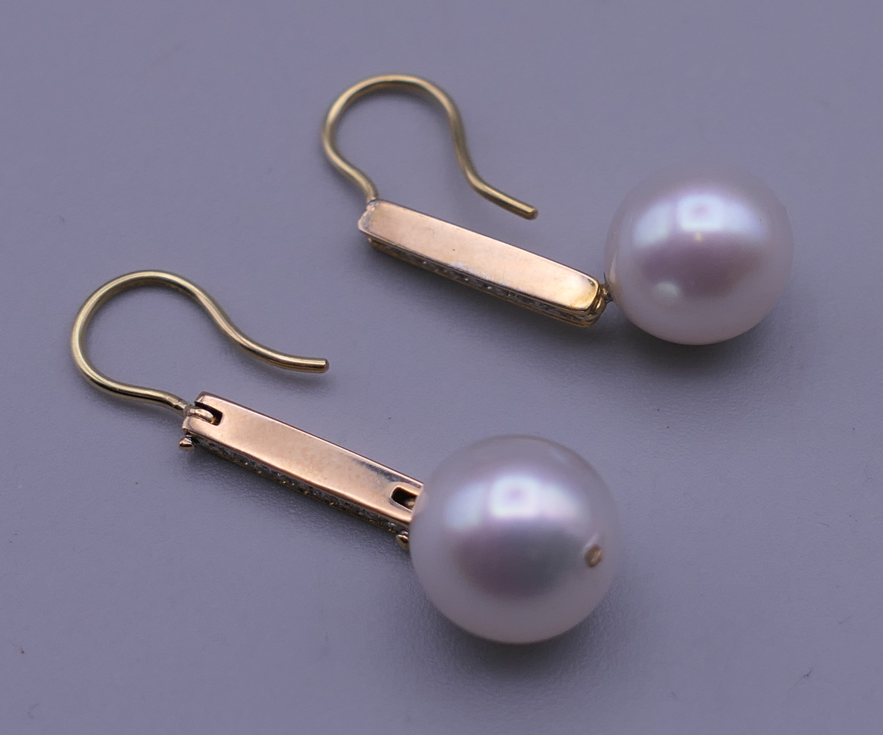 A pair of unmarked 18 K gold diamond and pearl earrings. 3.25 cm high. - Image 4 of 5