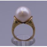 A 10-12mm pearl in 12 ct gold ring setting. Ring size I/J. 8.4 grammes total weight.