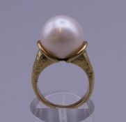 A 10-12mm pearl in 12 ct gold ring setting. Ring size I/J. 8.4 grammes total weight.