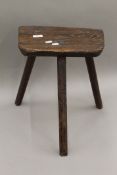 A 19th century oak three legged stool. 36.5 cm wide.