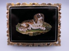 A fine 19th century micro mosaic depicting a King Charles Spaniel seated on a cushion mounted on an