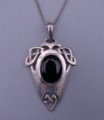 An Art Nouveau style silver onyx pendant by Kit Heath on a silver chain. The pendant 3.5 cm high.