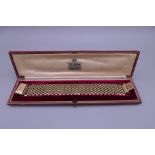 A 9 ct gold bracelet, retailed by Garrard & Co, housed in a fitted box. 19 cm long. 49 grammes.