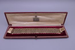 A 9 ct gold bracelet, retailed by Garrard & Co, housed in a fitted box. 19 cm long. 49 grammes.