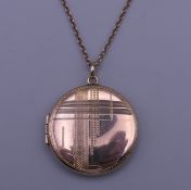 A 9 ct gold locket on a 9 K gold chain. The locket 2.5 cm diameter. 6.8 grammes total weight.