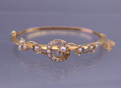 A gold seed pearl set bangle form bracelet. 6.25 cm wide. 7.1 grammes total weight.