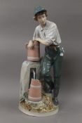 A large porcelain figure of a boy at a water pump. 61 cm high.