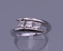 An 18 ct white gold square cut diamond three stone ring. Approximately 1.06 carats of diamond.