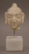 An Indian plaster bust mounted on white marble base. 20 cm high overall.