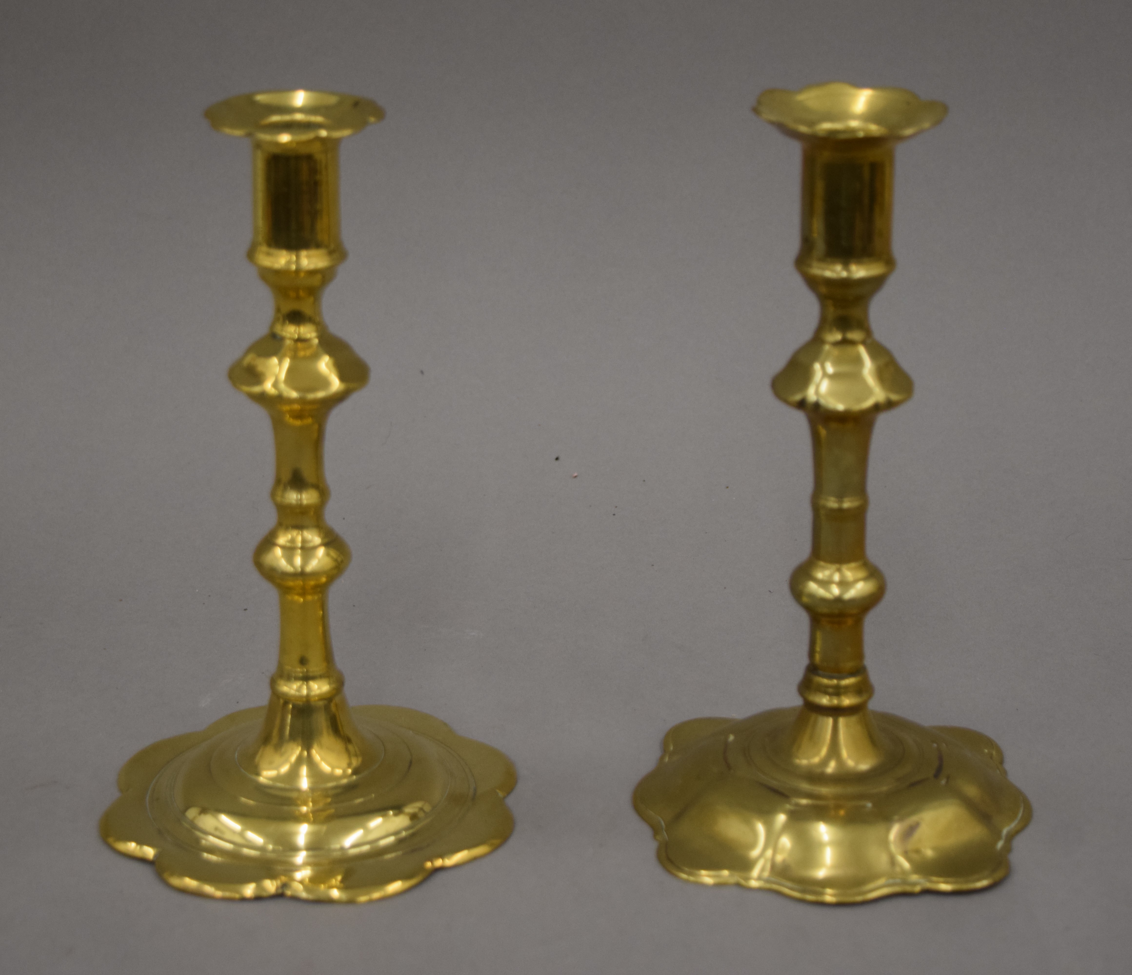 An 18th century brass candlestick with petal edge drip pan and base,